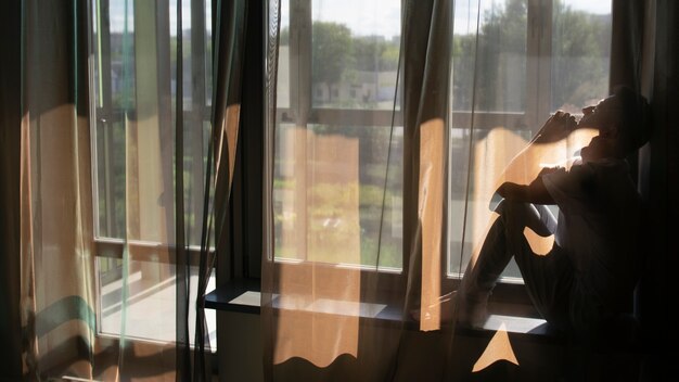 無料写真 カーテンと窓からの影を持つ成人男性の肖像画