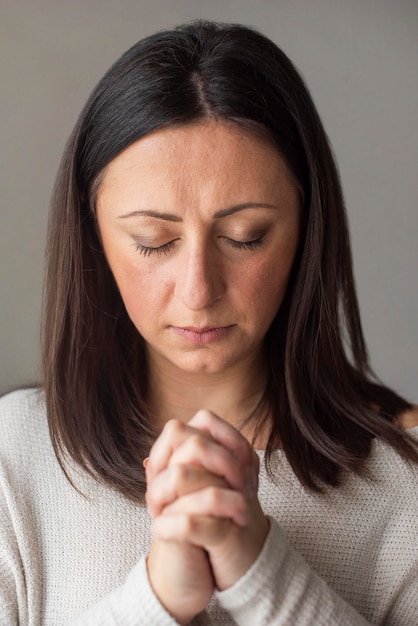 Бесплатное фото Портрет взрослой женщины молятся дома