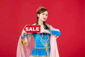 無料写真 赤の販売ネームプレートを保持している伝統的なドレスのアゼルバイジャン語の女性の肖像画