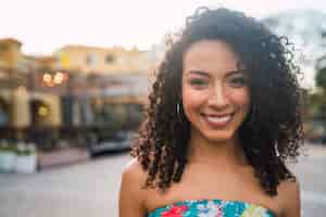 無料写真 通りで笑っている美しいアフロアメリカンラテン自信のある女性の肖像画。屋外。