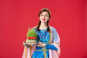 Бесплатное фото Портрет красивой азербайджанской женщины в традиционной одежде с семени на красном