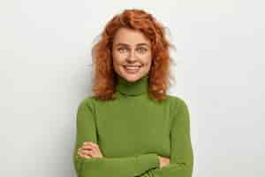 Бесплатное фото Портрет красивой девушки с короткими рыжими волосами, выглядит со счастливым расслабленным выражением лица