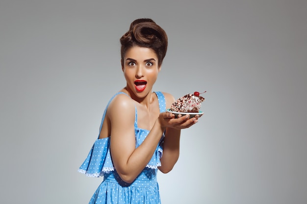 Бесплатное фото Портрет красивой очаровательной женщины, держащей торт в руках