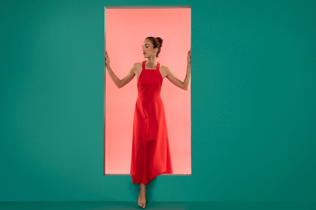 Бесплатное фото Портрет красивой женщины, позирующей в струящемся красном платье
