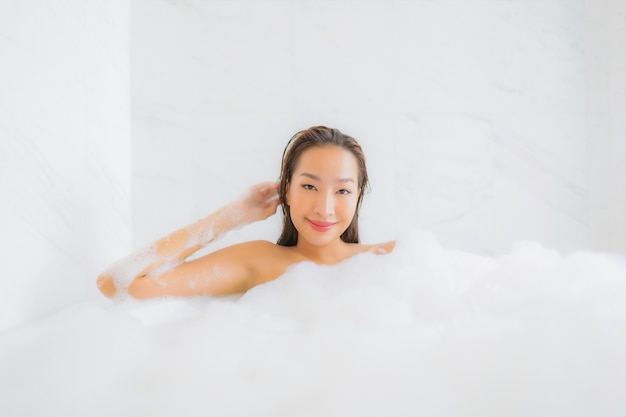 美しい若いアジアの女性の肖像画は浴槽でリラックス