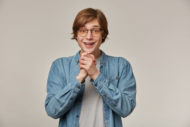 かっこいい男性 ブロンドの髪のハンサムな男 茶色のセーターと眼鏡をかけています 無料の写真