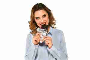 Бесплатное фото Портрет веселая молодая женщина, есть вкусный темный шоколад, завернутый в фольгу