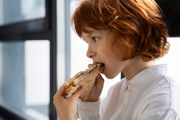 無料写真 学校でサンドイッチを食べる子供の肖像画