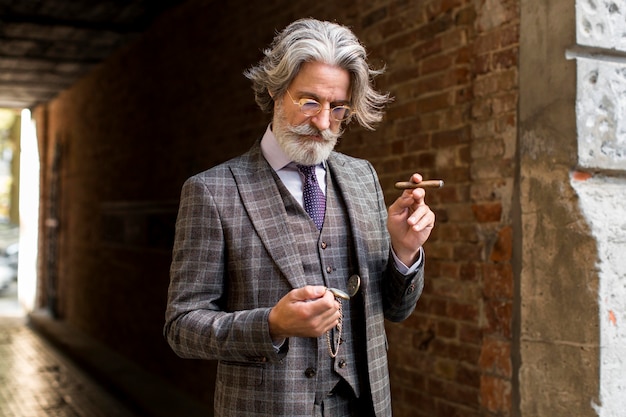 Бесплатное фото Портрет уверенного мужчины, держащего сигару