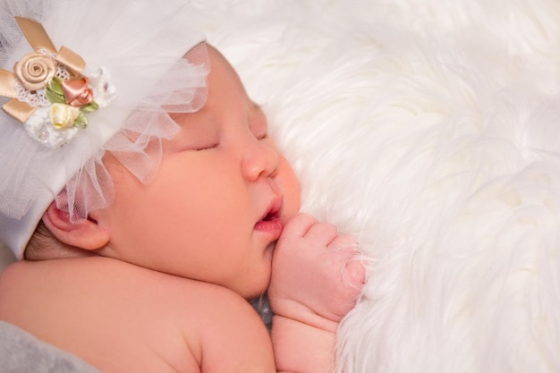 かわいい眠っている新生児の肖像画と白い毛皮の毛布の上のコピースペース