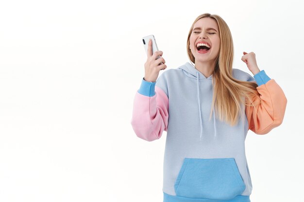 左を指して驚いて幸せな女の子 製品の広告をお勧め 大丈夫なジェスチャーを作る 無料の写真