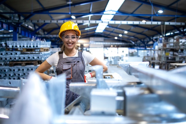 Бесплатное фото Портрет работницы фабрики, стоящей в производственном цехе