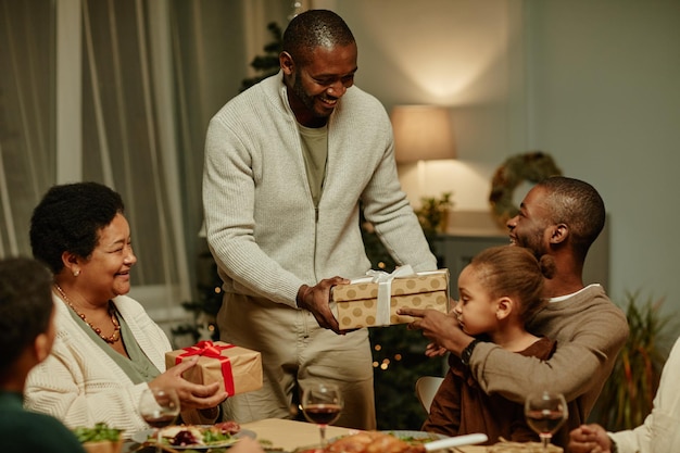 집에서 함께 크리스마스를 즐기면서 선물을 교환하는 행복한 아프리카계 미국인 가족의 초상화