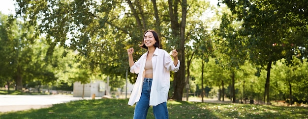 무료 사진 행복한 소녀의 초상화 춤추고 행복하게 보이는 공원에서 포즈를 취하고 혼자  ⁇ 는 것을 즐긴다