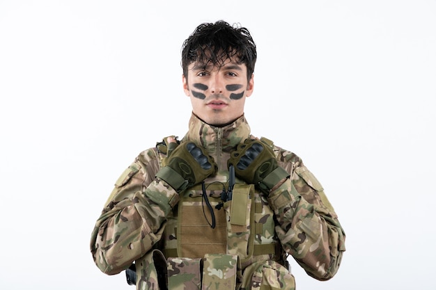 Бесплатное фото Портрет мужчины-солдата в камуфляже, готового к войне на белой стене