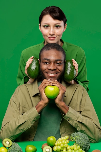 무료 사진 녹색 과일을 들고 여자와 남자의 초상화