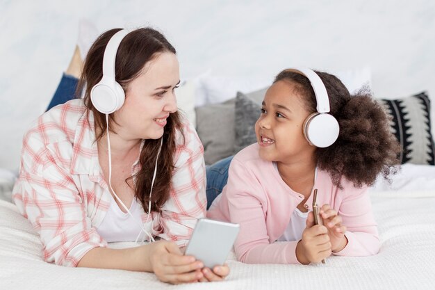 Бесплатное фото Портрет матери слушает музыку с дочерью