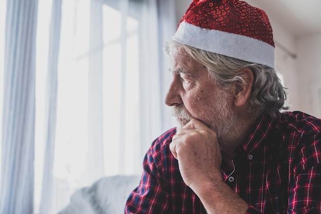 一​人​で​、​孤独​で​、​コロナ​ウイルス​の​ために​彼​の​家族​から​隔離された​クリスマス​の​日​を​祝う​彼​の​家​の​ソファ​に​座っている​一​人​の​老人​と​成熟した​男​の​肖像画