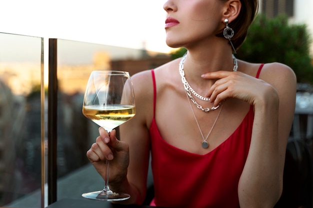 무료 사진 야외에서 와인을 마시는 부자 여성의 초상화