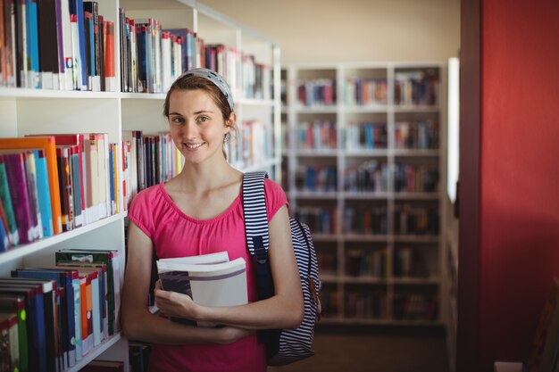 図書館で本を彼女の顔を隠す女子高生の肖像画 プレミアム写真