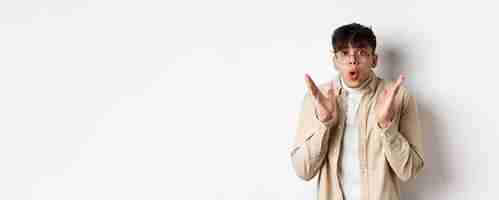 무료 사진 멋진 프로모션을 확인하는 안경을 쓴 놀란 힙스터 남자의 초상화는 와우와 헐떡이며 놀란 r