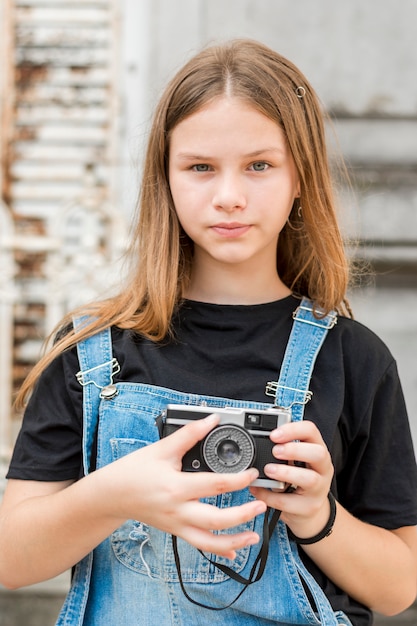 Портрет подростковой красивой девушки с ретро-камерой