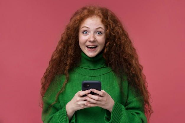 Бесплатное фото Портрет девочки-подростка, взволнованной игрой на своем смартфоне