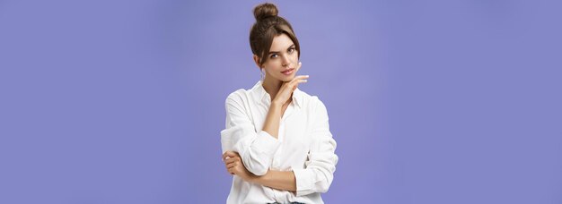 Бесплатное фото Портрет нежной и женственной стильной женщины в белой блузке, чувственно и кокетливо позирующей