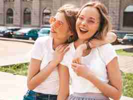 無料写真 トレンディな夏の白いtシャツ服で流行に敏感な女の子を笑顔2つの若い美しいブロンドの肖像画。
