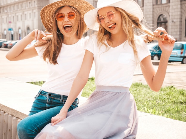 無料写真 トレンディな夏の白いtシャツ服で流行に敏感な女の子を笑顔2つの若い美しいブロンドの肖像画。