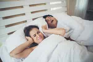Бесплатное фото Портрет женщины, блокирующие уши с человеком, спящим храпом на кровати