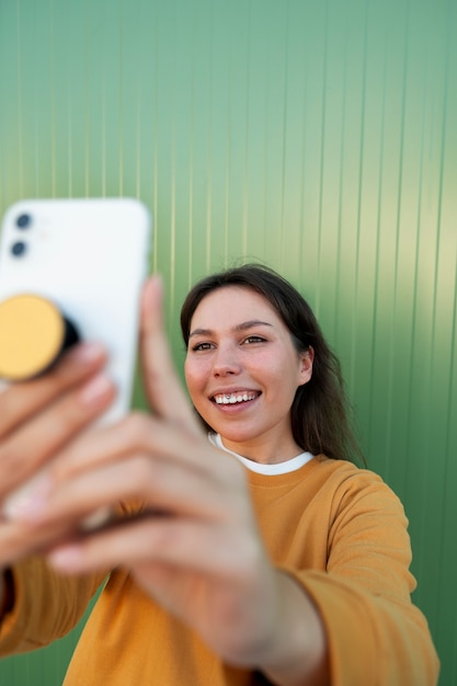 ポップ ソケットを屋外でスマートフォンを使用している女性の肖像画