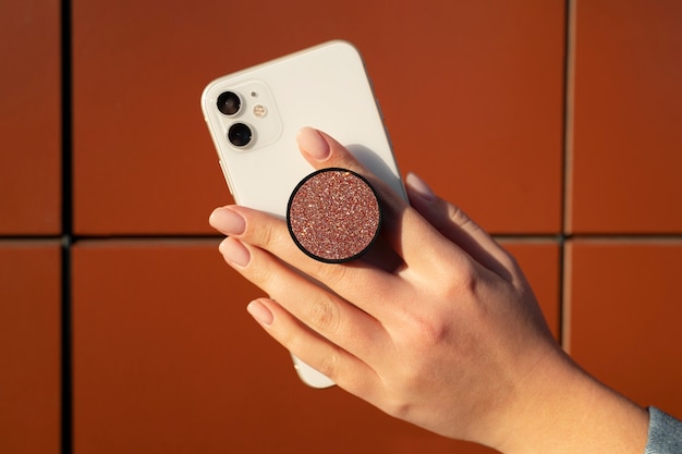 無料写真 ポップ ソケットを屋外でスマートフォンを使用している女性の肖像画