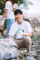 Портрет молодых взрослых азиатских людей добровольно работают в команде по сохранению окружающей средыдобровольцы помогают собирать пластиковый и пенопластовый мусор в парковой зоневсемирный день окружающей среды волонтеров
