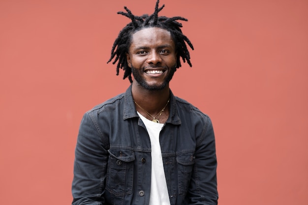 Бесплатное фото Портрет молодого человека с афро дредами и курткой