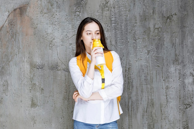 Портрет молодой женщины, выпивая бутылку воды. фото высокого качества