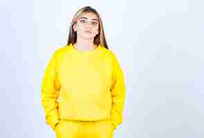 無料写真 ポーズと立っている黄色の衣装で若い女性の肖像画