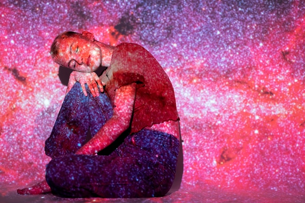 無料写真 宇宙投影テクスチャでポーズをとって若い女性の肖像画