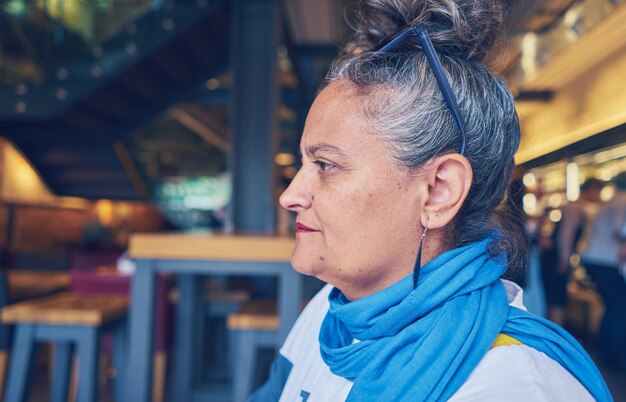 Portrait of an old stylish woman sitting in a restaurant