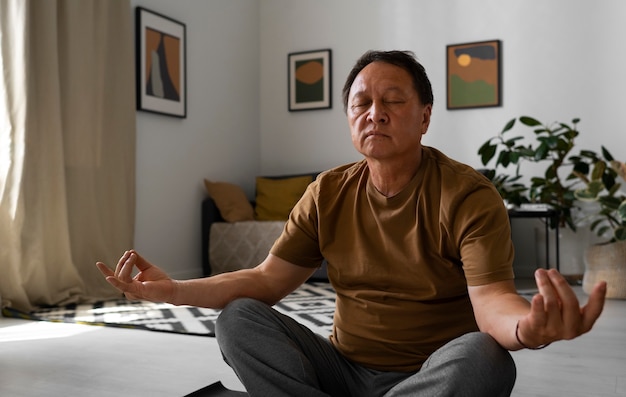 Портрет пожилого мужчины, медитирующего дома