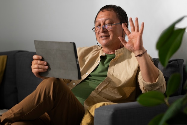 Free photo portrait of older man using tablet at home