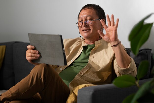 Portrait of older man using tablet at home