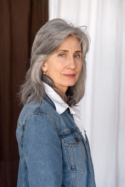 Portrait of older woman posing in a jean jacket