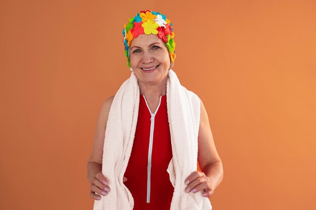 Portrait of older woman with floral swim cap and towel