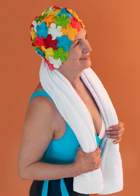 Portrait of older woman with floral swim cap and towel