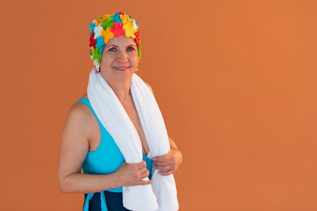 Portrait of older woman with floral swim cap and towel