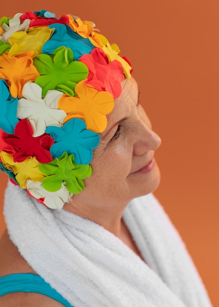 Free photo portrait of older woman with floral swim cap and towel