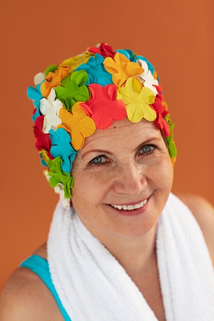 Portrait of older woman with floral swim cap and towel