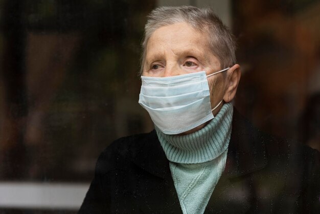 医療マスクを持つ年上の女性の肖像画