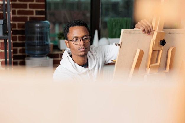 Free photo portrait of painter student looking at vase sketching model using drawing graphic pencil. team of creative students learning sketch technique creating modern artwork on canvas. new years resolutions